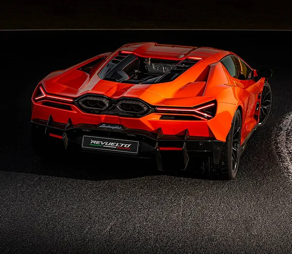 Rear view of an orange Lamborghini Revuelto on a race track kerb