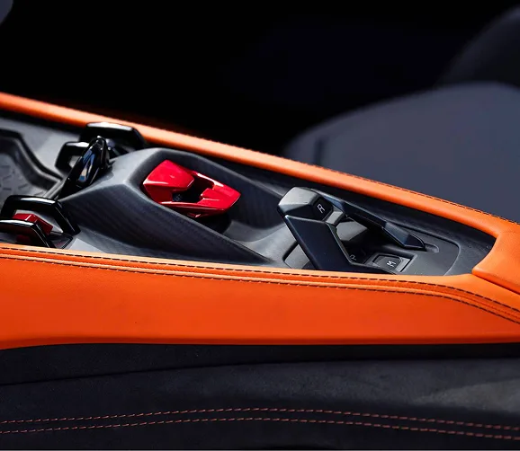Lamborghini Revuelto centre console in orange leather with the red starter cover