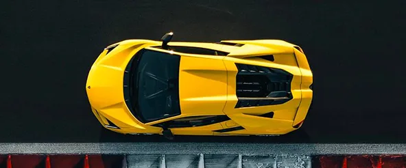 Overhead view of a yellow Lamborghini Revuelto on a race track start line